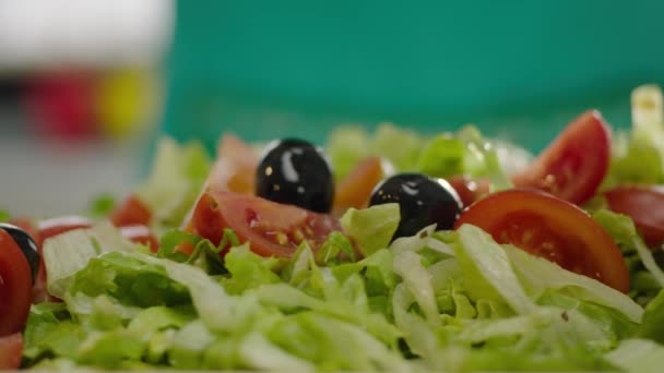 câmera lenta de azeitonas pretas que caem na salada
  - Filmagem, Vídeo