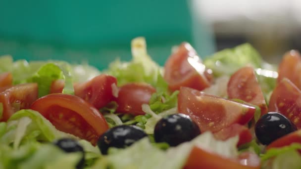 Slow Motion van zwarte olijven die in salade vallen  - Video