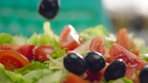 Zeitlupe schwarzer Oliven im Salat  - Filmmaterial, Video