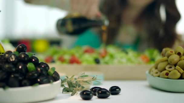 vrouw gieten gemengde salade met tomaten, wortelen, kool door olijfolie  - Video