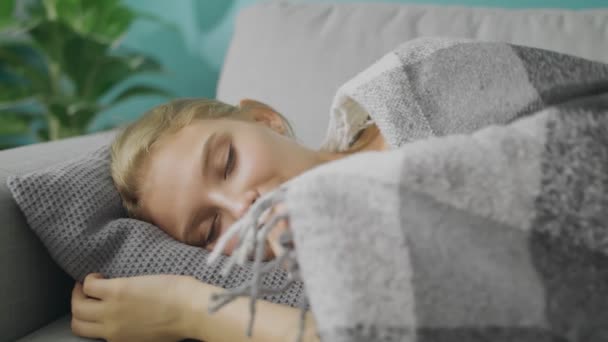 A young woman wakes up on a couch in a cozy living room - Filmagem, Vídeo