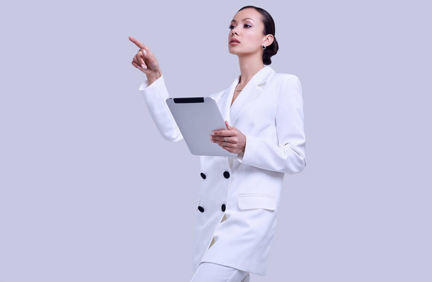 hinreißende lateinamerikanische Frauen im modischen weißen Anzug mit digitalem Tablet - Foto, Bild