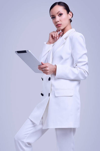 hinreißende lateinamerikanische Frauen im modischen weißen Anzug mit digitalem Tablet - Foto, Bild