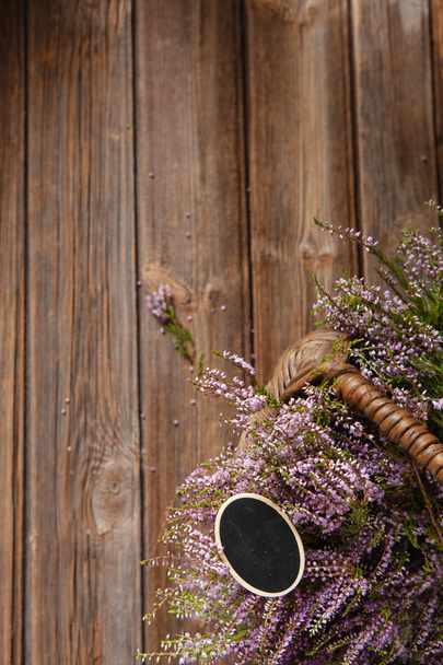 Beautiful fresh bouquet of blooming forest heather in basket  - Fotó, kép