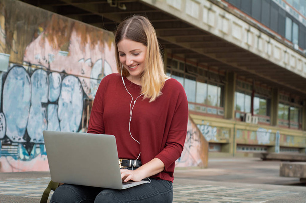 Young student using laptop outdoors.  - Foto, Bild