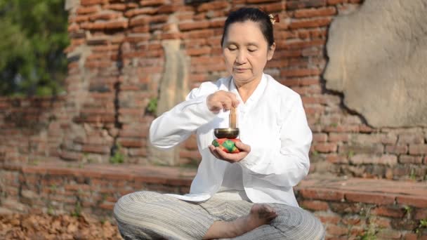 Nainen pelaa tiibetiläinen kulho, perinteisesti käytetty apuna meditaatio buddhalaisissa kulttuureissa
. - Materiaali, video