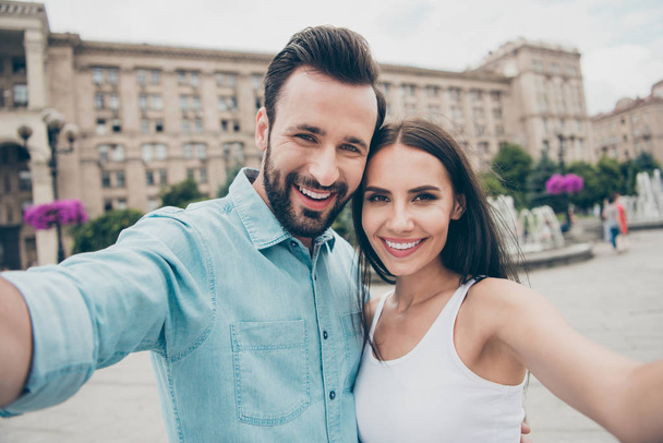 Close up photo of charming nice pretty attractive lady guy video call spring face make photo moment positive cheerful enjoy weekend free time blue shirt denim jeans white singlet top town outside - Valokuva, kuva