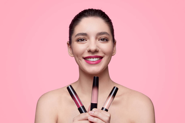 Smiling female with set of lipsticks - Foto, afbeelding