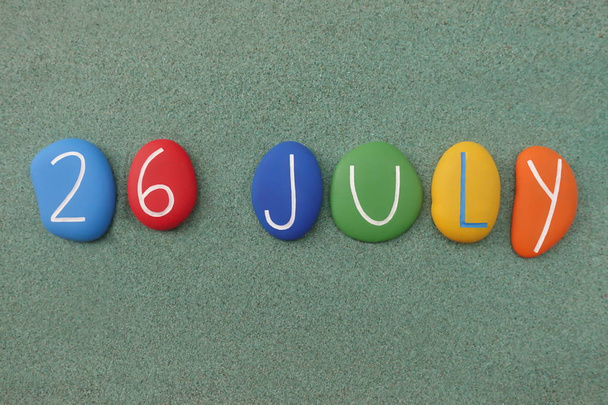 26 Juillet, date du calendrier composé de pierres multicolores sur sable vert
 - Photo, image