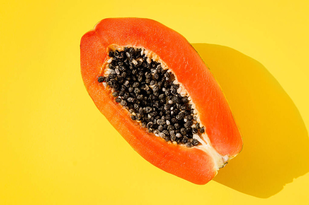 Świeże papaja egzotyczne owoce tropikalne na żółtym tle. Słońce światło dzienne oświetlenie. Minimalistyczne lato płasko leżał tapety. Kreatywna koncepcja żywności. Skopiuj szablon spacji. Pogrubienie kolorów - Zdjęcie, obraz