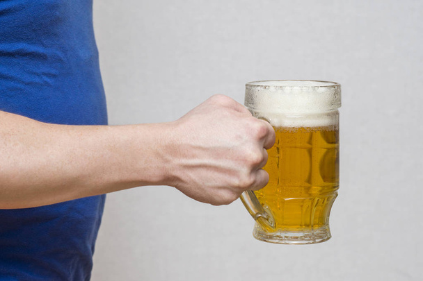Hand Hold glazen mok van bier op witte achtergrond. Bier in een glas met de hand - Foto, afbeelding