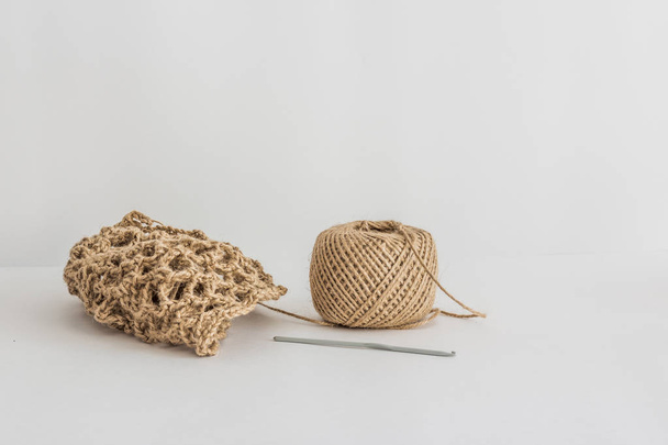 Jute tangle and knitted product on a white background. Eco product - Photo, Image