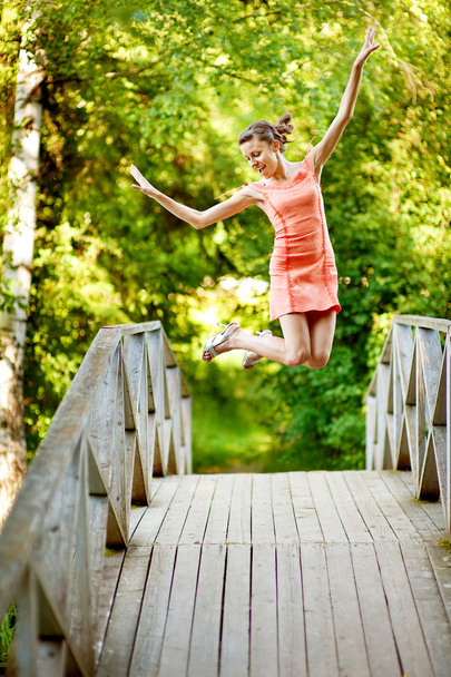 Saltar chica en el puente de verano
 - Foto, Imagen