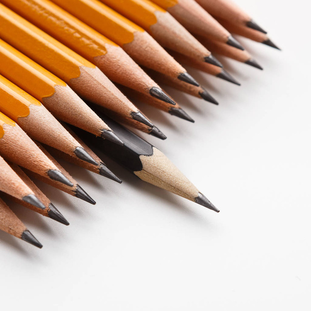 Один чорний олівець провідна група класичних жовтих олівців
 - Фото, зображення