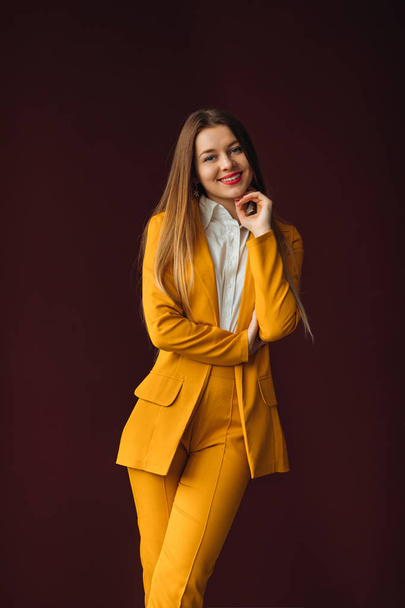 mujer de negocios posando en un elegante traje amarillo contra el backgr
 - Foto, imagen