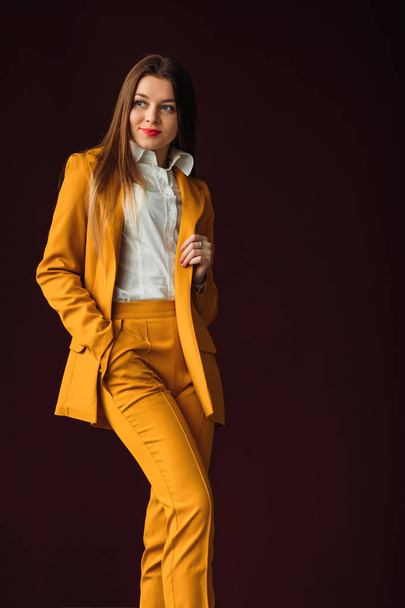 kobieta interesu pozowanie w stylowy żółty garnitur przeciwko ekspresyjne - Zdjęcie, obraz