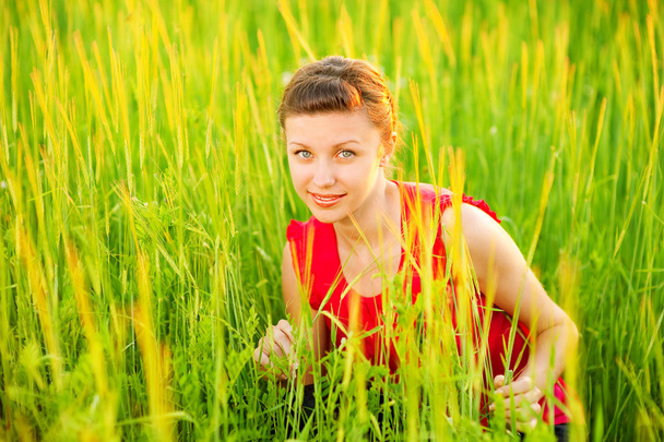 Menina bonita jovem senta-se no prado
 - Foto, Imagem