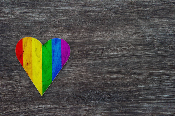 Dekoracyjne serce z Rainbow Stripes na szarym drewnianym tle. Flaga dumy LGBT. - Zdjęcie, obraz