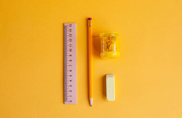 Bright yellow pencil with sharpener, wooden ruler and eraser for - Фото, изображение