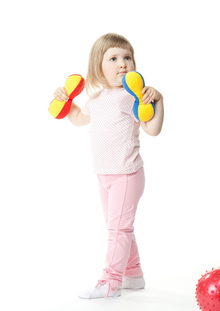 Baby girl doing exercises with toy dumbbells - Foto, imagen