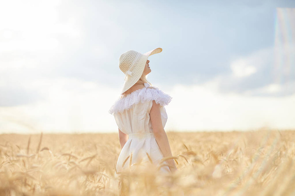 gündüz sırasında buğday alanında şapkalı beyaz kadın - Fotoğraf, Görsel