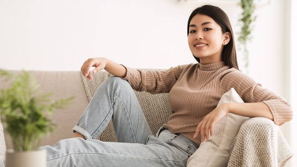 Girl Resting on Comfortable Sofa and Posing to Camera - Foto, imagen