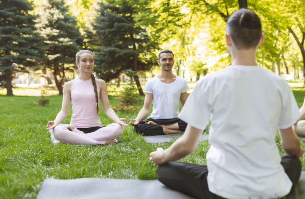 Profesora de Yoga y principiantes en clase outdoor, haciendo posturas fáciles
 - Foto, imagen
