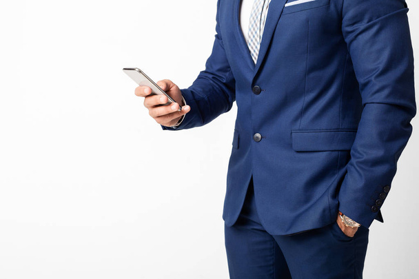 Businessman using smartphone and texting over white background - Photo, Image
