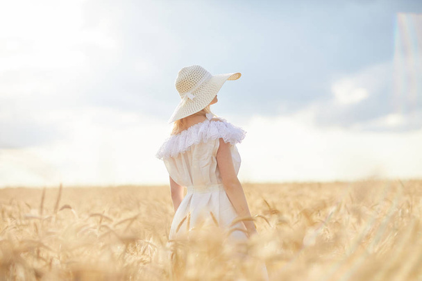 gündüz sırasında buğday alanında şapkalı beyaz kadın - Fotoğraf, Görsel