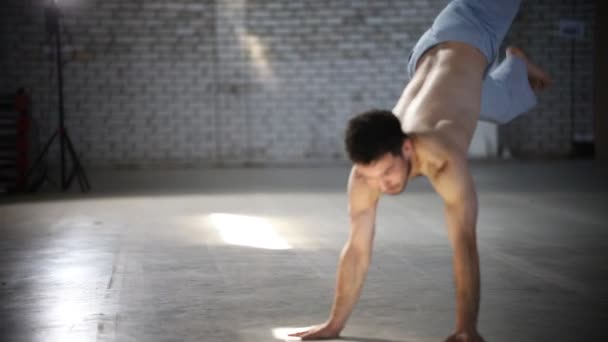 Adam elleri üzerinde atlama ve ayakları yukarı kaldırarak, sonra etrafında döner ve hareketleri tekrarlar - capoeira elemanları gösteren - Video, Çekim