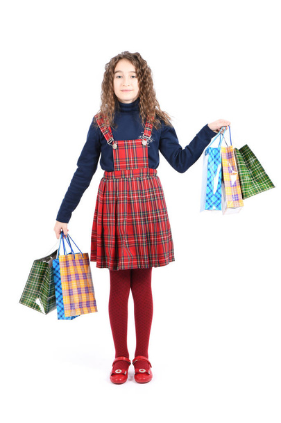 Child with a packaging checkered texture isolated on white background. Girl likes shopping on sale season. Holiday present, shopping.  - Foto, immagini