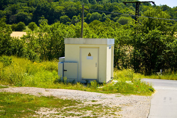 田舎道の電力供給業者の変圧器の家 - 写真・画像