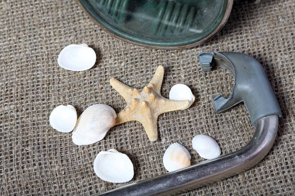 Starfish, shells and a mask with a snorkel for scuba diving. They lie on a rough linen fabric. - Foto, immagini