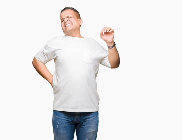 Middle age arab man wearig white t-shirt over isolated background stretching back, tired and relaxed, sleepy and yawning for early morning - Фото, изображение