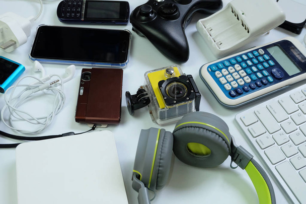Veel gebruikte moderne elektronische gadgets voor dagelijks gebruik op witte vloer, hergebruik en Recycle concept, Top View. - Foto, afbeelding
