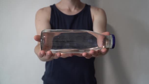廃棄物ゼロの概念。ペットボトルの代わりにガラス瓶を使用する。グリーンと意識的なライフスタイルのコンセプト。外出先で再利用可能な飲み物のアイデア。彼の前で再利用可能なガラスを持っている男. - 映像、動画