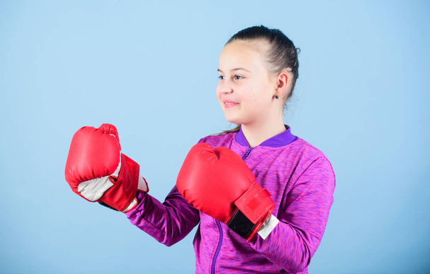 Full concentration. Happy child sportsman in boxing gloves. Sport success. sportswear fashion. workout of small girl boxer. Fitness diet. energy health. punching knockout. Childhood activity - Foto, afbeelding