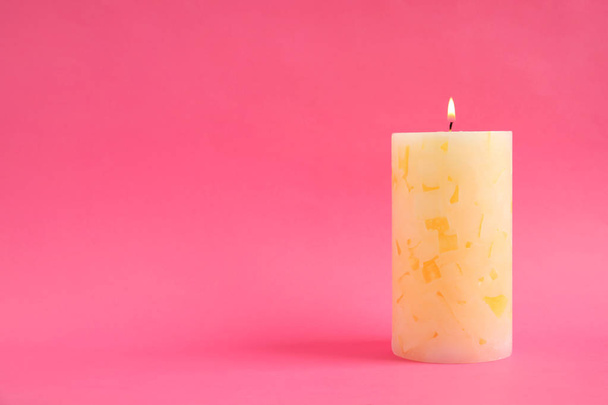 Alight wax candle on color background. Space for text - Фото, зображення