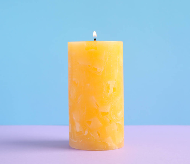 Alight scented wax candle on color background - Фото, изображение