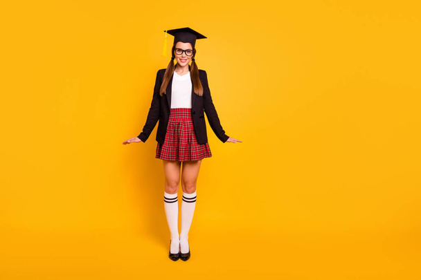 Full length body size view photo charming youth people posing eyewear eyeglasses pigtail ponytail knee-socks grad red skirt checked plaid long black jacket isolated yellow background - Photo, image