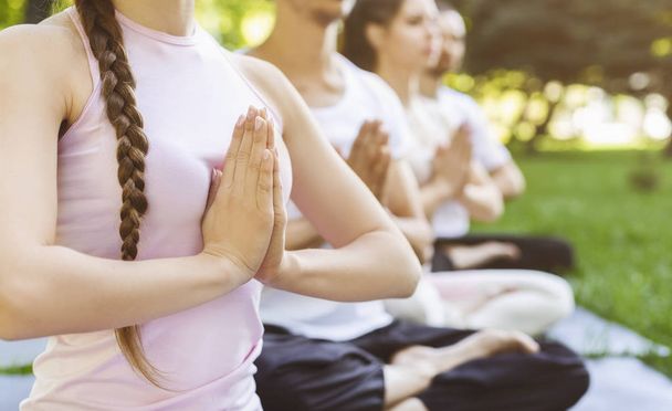 Close up of people making namaste gesture at yoga class outdoors - 写真・画像