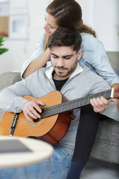 loving couple with guitar in the room at home - Foto, Bild