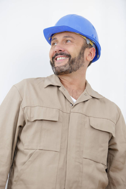 Усміхнений працівник перед будівельним майданчиком
 - Фото, зображення