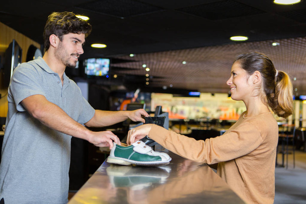 bowling center staff giving the bowling shoes - Foto, Bild