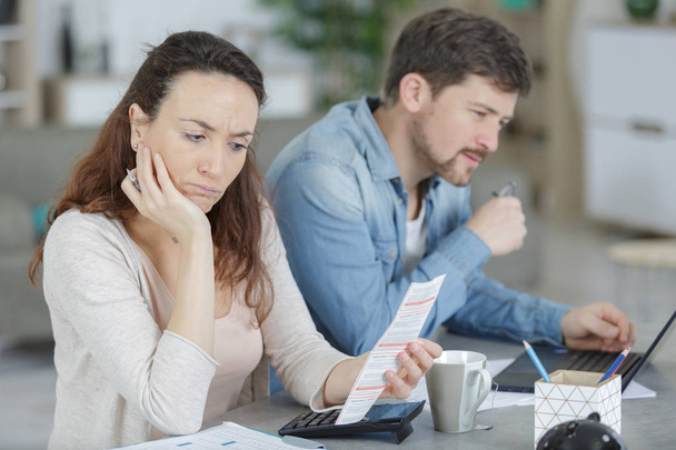 couple looking anxiously at paperwork - 写真・画像