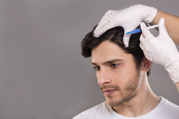 Homem com problema de perda de cabelo recebendo injeção na cabeça
 - Foto, Imagem