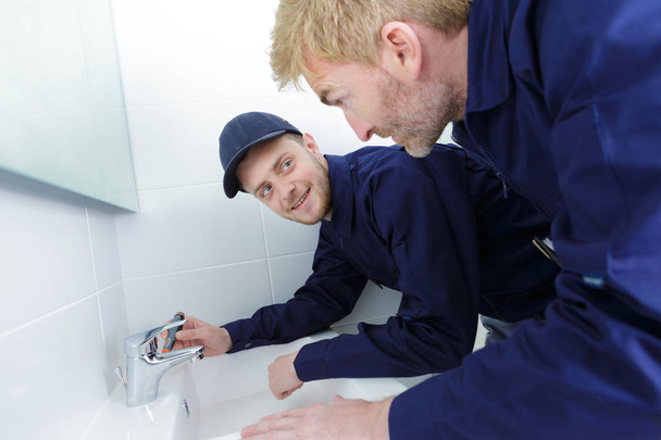 establishment maintenance plumber fixing a sink - Foto, afbeelding