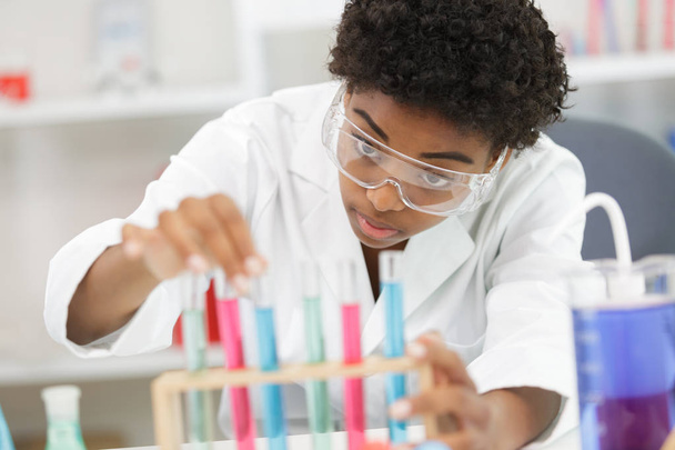 female lab worker looking at pipettes - Φωτογραφία, εικόνα