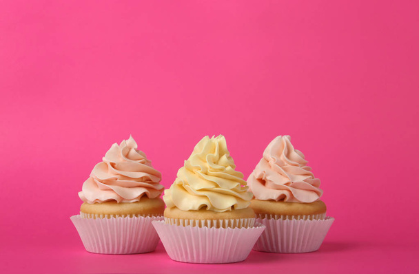 Tasty cupcakes with cream on pink background - Φωτογραφία, εικόνα