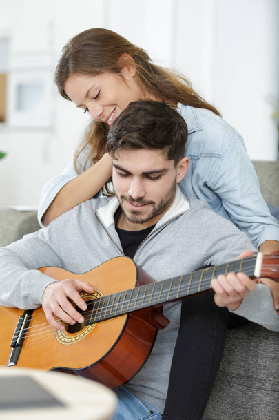 lady listening to her boyfriend play the guitar - Fotografie, Obrázek